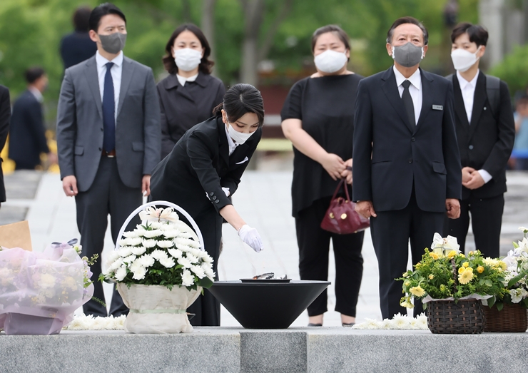 김건희 여사가 6월 13일 봉하마을을 방문했을 때 검정옷을 입고 빨간 가방을 든 여성(김 여사 오른쪽)은 무속인으로 오해를 받았으나, 김 여사의 지인 김 모 교수인 것으로 전해졌다. [연합]