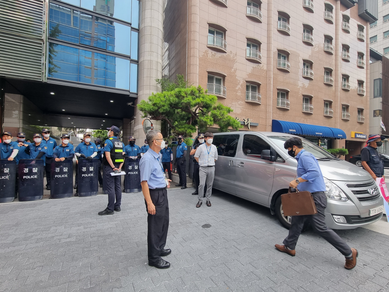 17일 오전 서울 강남구 청담동 하이트진로 본사에 직원들이 출근하는 모습. 본사 측 직원으로부터 사원증을 확인받은 뒤 건물 주차장 쪽으로 들어가고 있다. 김영철 기자