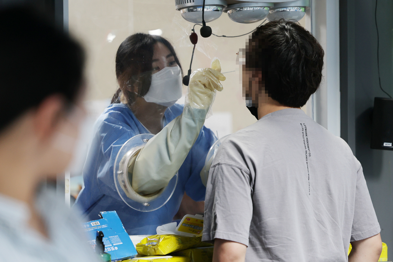 코로나19 재유행이 지속되고 있는 가운데 18일 오전 서울 용산구보건소 선별진료소에서 의료진이 검체채취를 하고 있다. [연합]
