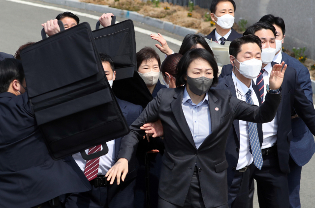 지난 3월 24일 박근혜 전 대통령이 대구 달성군 사저에 도착해 대국민 담화문을 밝히던 중 갑자기 소주병이 날아들자 경호원들이 박 전 대통령을 보호하고 있다. [연합]