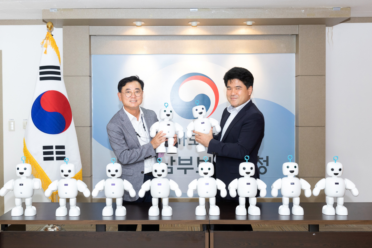 지난 18일 서울남부보훈지청에서 최형식(왼쪽) 효성 커뮤니케이션실 상무가 강병구 서울남부지청장에게 고령 국가유공자를 위한 반려로봇 ‘파이보’ 전달 후 기념사진을 찍고 있다. [효성 제공]