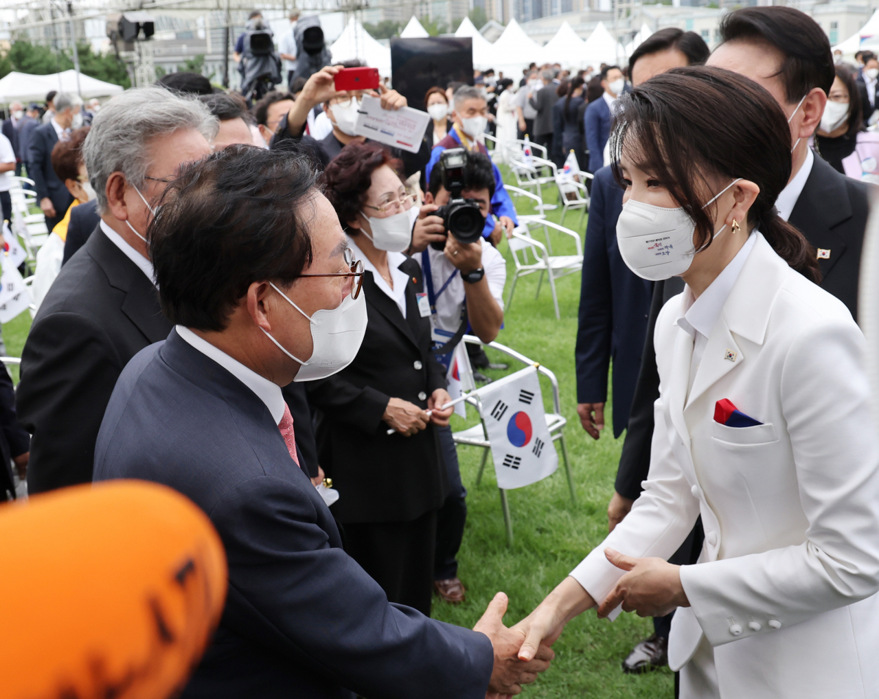 김건희 여사가 이달 15일 서울 용산 대통령실 청사 잔디마당에서 열린 제77주년 광복절 경축식이 끝난 뒤 윤석열 대통령에 이어 참석자들과 인사하고 있다. [연합]