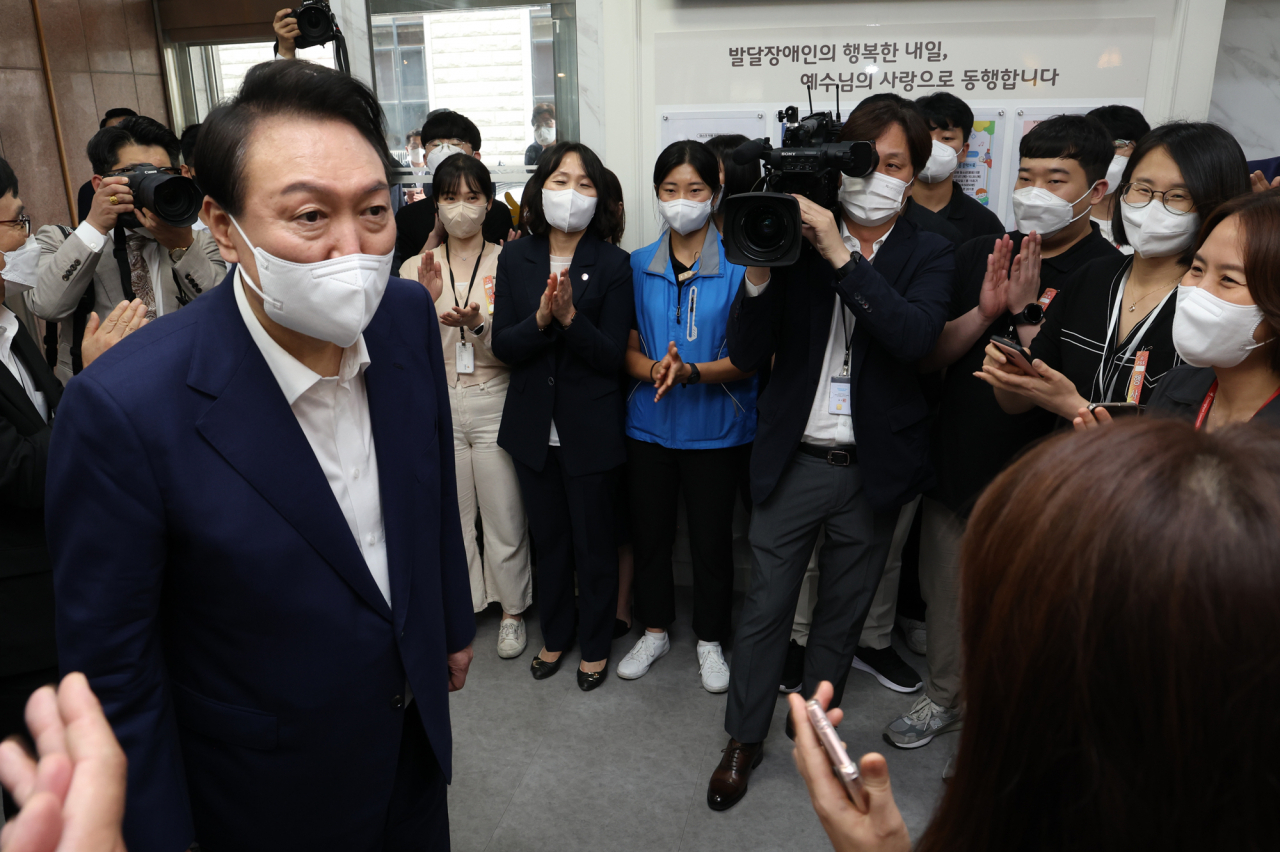 윤석열 대통령이 18일 오후 발달장애인 교육현장인 서울 강남구 역삼동 충현복지관 방문을 마친 뒤 직원들을 격려하고 있다. [연합]