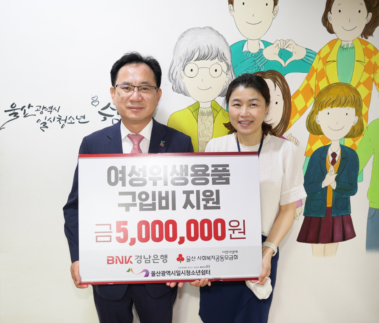 BNK경남은행 이상봉 상무가 울산광역시일시청소년쉼터 이영은 소장에게 ‘여성위생용품 구입 성금 기탁 증서’를 전달하고 있다. [BNK경남은행 제공]