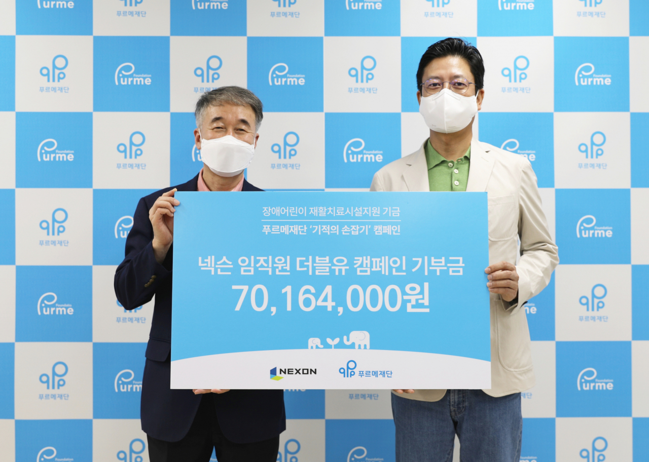 넥슨-푸르메재단 ‘더블유WEEK’ 기부금 전달식에서 백경학 푸르메재단 상임이사(왼쪽)와 김정욱 넥슨코리아 부사장(넥슨재단 이사장)이 기념촬영을 하고 있다.