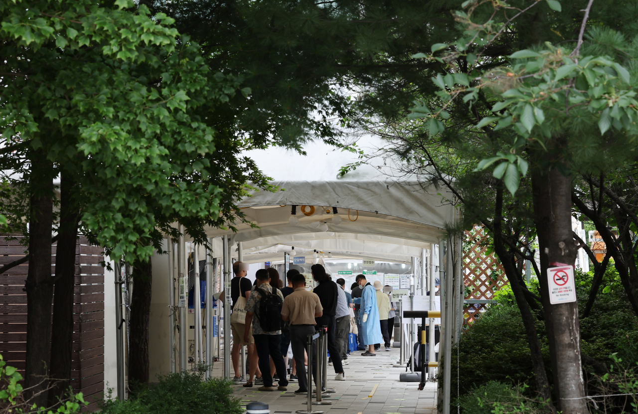 People wait to get tested for COVID-19 at a testing center in the western ward of Mapo, Seoul, on Friday. (Yonhap)