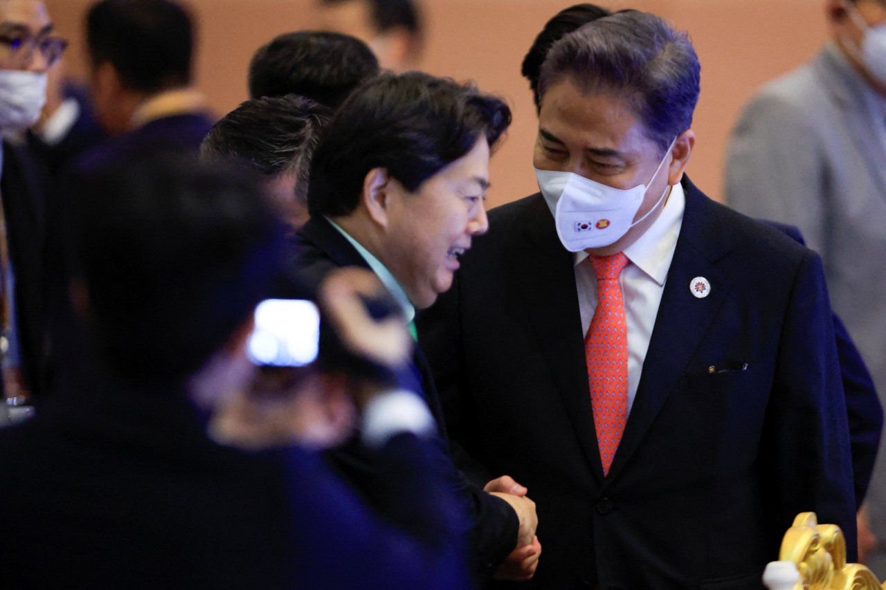 South Korean Foreign Minister Park Jin (R) shakes hands with Japanese Foreign Minister Yoshimasa Hayashi during a meeting with their counterparts from the Association of Southeast Asian Nations in Phnom Penh on Aug. 4, 2022. (Yonhap)