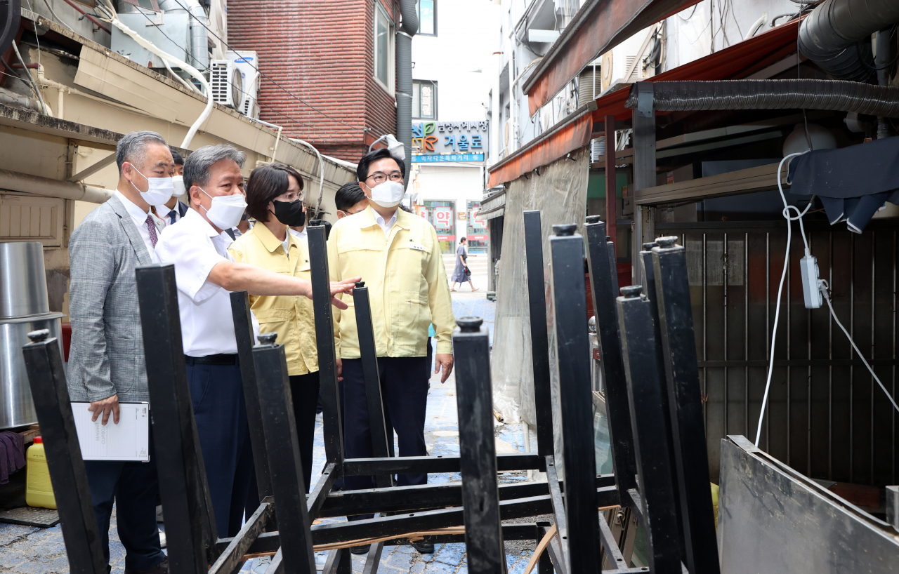 이영 중소벤처기업부장관(왼쪽 세 번째)과 박일하 동작구청장(왼쪽 네 번째)이 서울 동작구 남성사계시장 수해현장을 찾아 침수 피해를 본 상가를 둘러보고 있다. [연합]