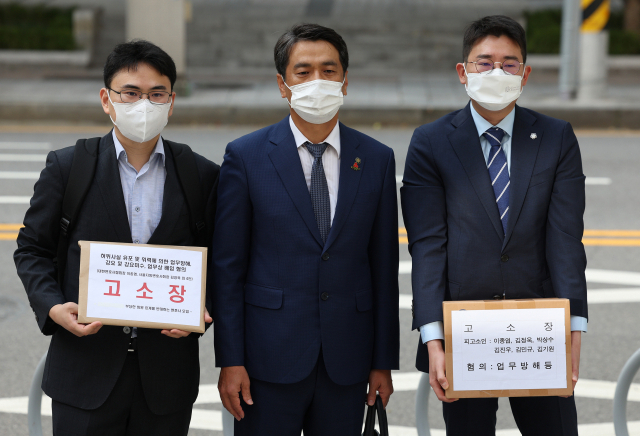 ‘광고 규정 개악과 부당한 회원 징계를 반대하는 변호사 모임’ 소속 윤성철(가운데) 변호사 등이 16일 서울 종로구 서울경찰청 민원실 앞에서 고소장을 들고 이동하고 있다. [연합]