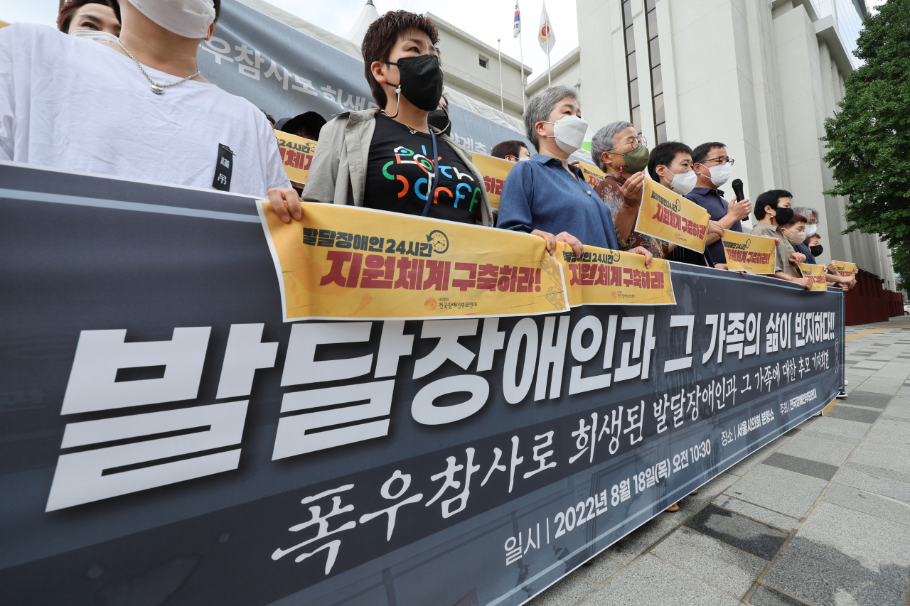 지난 18일 전국장애인부모연대 관계자들이 서울 중구 서울시의회 앞에서 열린 ‘폭우 참사로 희생된 발달장애인과 그 가족에 대한 추모 기자회견’에서 발달장애인 지원체계 구축을 촉구하고 있다. [연합]