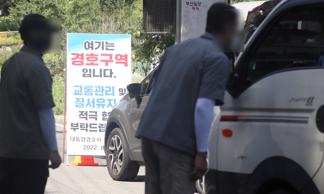 문재인 전 대통령 내외 사저 경호 강화 첫날인 22일 오전 사저에서 300여ｍ 떨어진 경남 양산시 하북면 평산마을 입구에 '여기는 경호구역입니다. 대통령 경호처·양산경찰서'라고 표기돼 있다. 경호처가 방문차량에 대해 방문 목적 등을 묻는 모습. [연합]