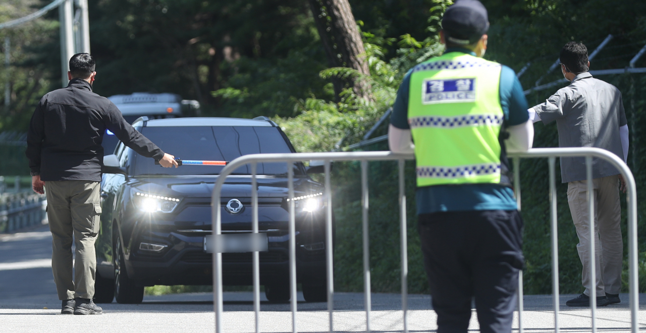 문재인 전 대통령 내외 사저 경호 강화 첫날인 22일 오전 사저에서 300여ｍ 떨어진 경남 양산시 하북면 평산마을 입구에서 경호처 직원이 방문객에게 방문 목적 등을 묻고 있다. [연합]
