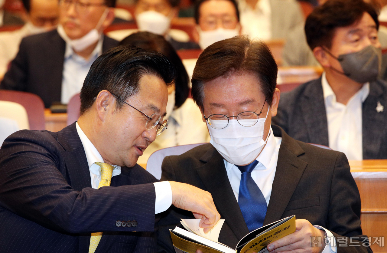 이재명 더불어민주당 대표 후보(오른쪽)가 22일 오후 국회박물관 내 체험관에서 열린 박성준 의원(서울 중구·성동구을)의 ‘스피치의 정치’ 출판기념회에서 저자 박 의원으로부터 책을 소개받고 있다. [연합]