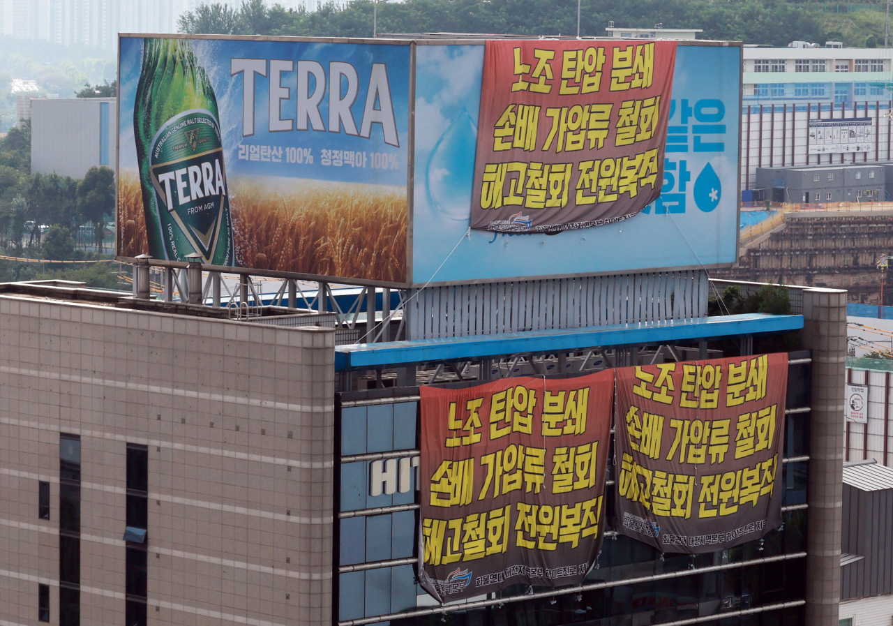 이달 22일 오전 전국민주노동조합총연맹(민주노총) 공공운수노조 화물연대가 점거 농성 중인 서울 강남구 하이트진로 본사 벽면에 ‘노조 탄압 분쇄’, ‘손배 가압류 철회’, ‘해고철회 전원복직’ 등 내용이 담긴 현수막이 걸려 있다. [연합]