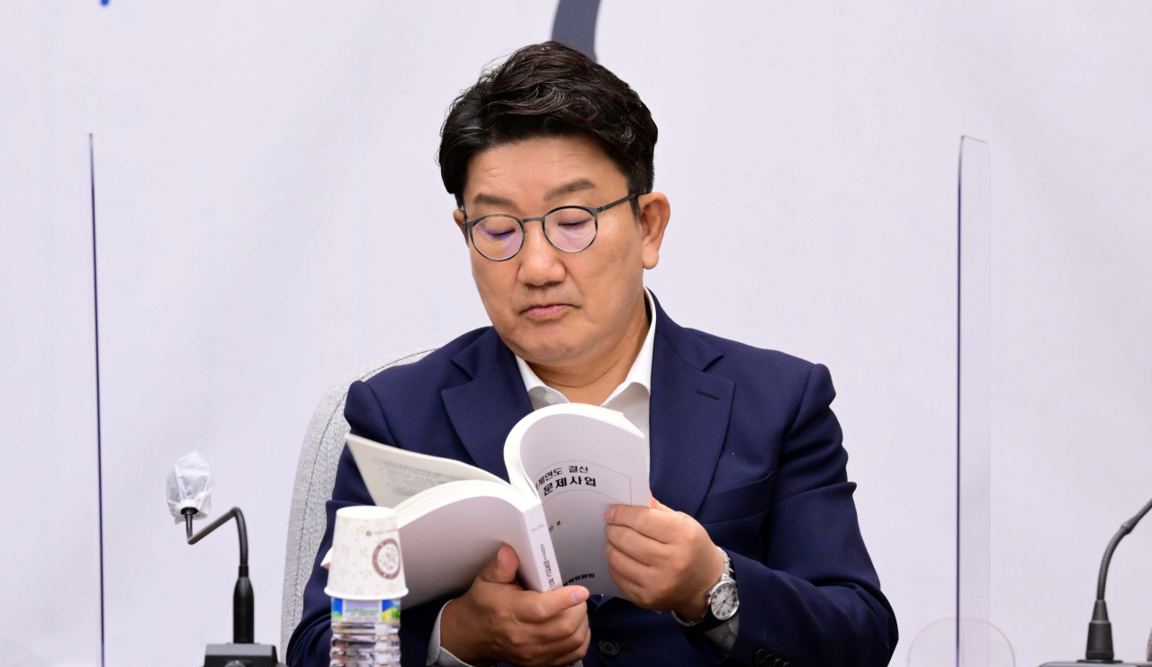 권성동 국민의힘 원내대표가 23일 오전 국회에서 열린 원내대책회의에서 발언을 마친 뒤 '2021 회계연도 결산 100대 문제사업' 책자를 살펴보고 있다. [연합]