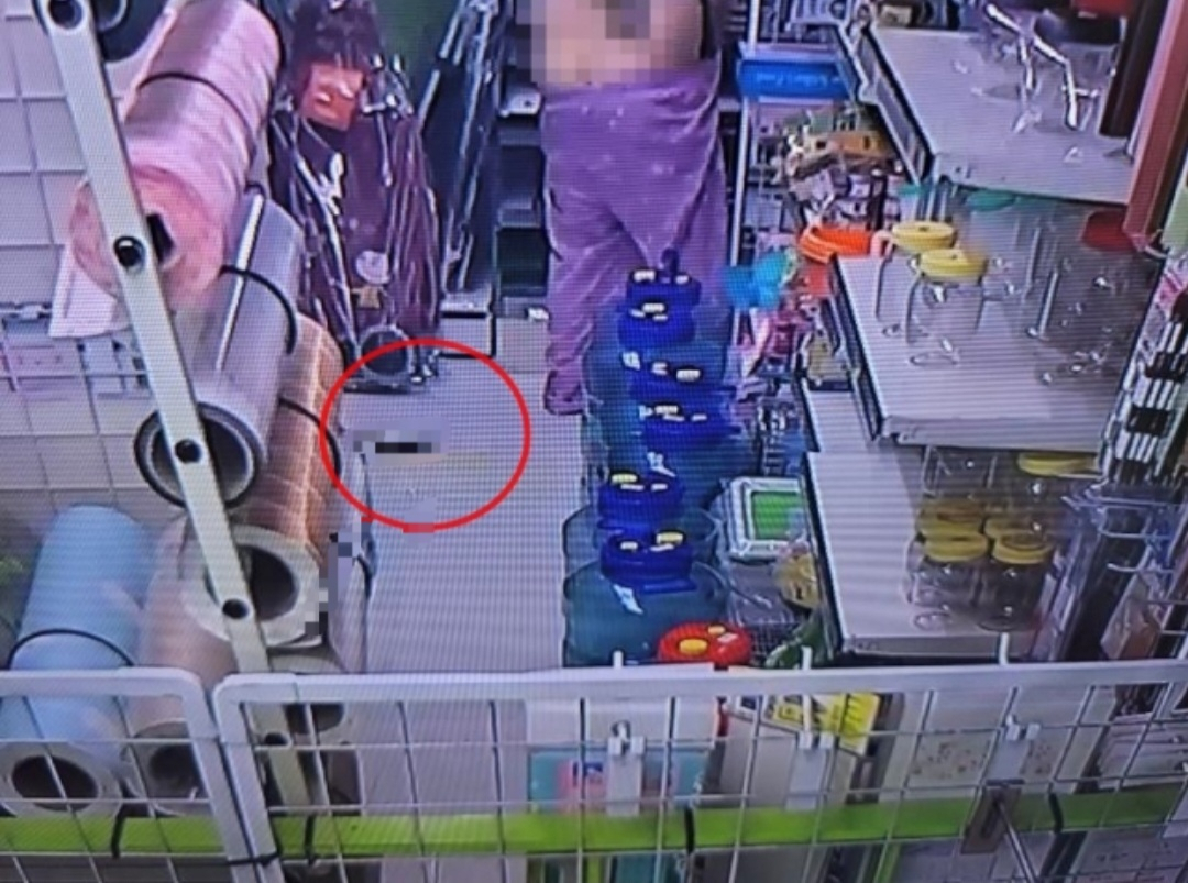 환자복을 입은 여성이 바지를 올리고 있고 왼쪽 아래 매장 바닥에는 대소변으로 보이는 물체가 있다. [보배드림]