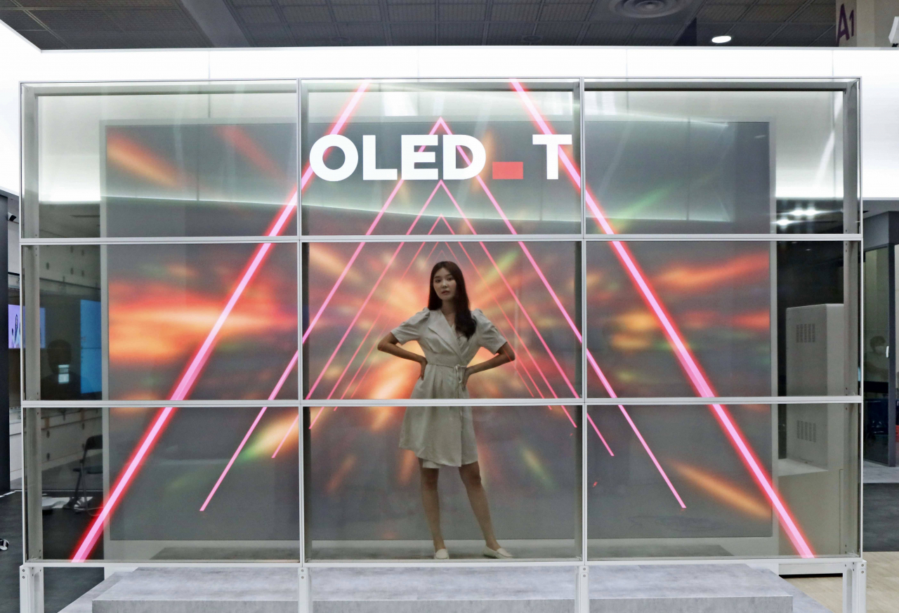 지난 10일 서울 코엑스에서 열린 'K-디스플레이 2022'에서 55인치 투명 OLED 9대로 홀로그램을 구현한 LG디스플레이 ‘투명 포토월’ 체험 모습[LG디스플레이 제공]