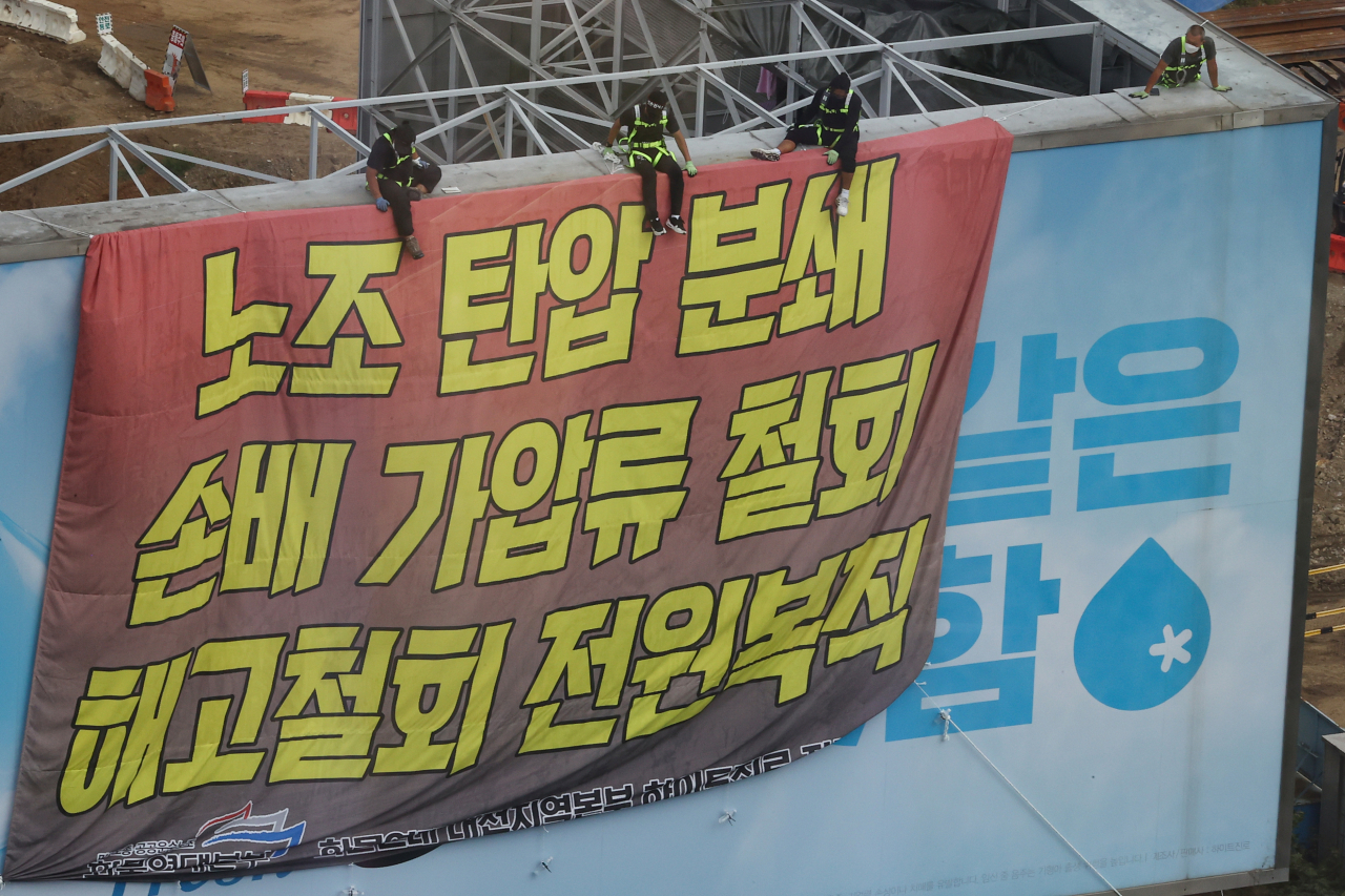 서울 강남구 하이트진로 본사에서 고공 농성을 펼치고 있는 화물노동자들이 지난 18일 하이트진로 본사 앞에서 열린 ‘고공농성투쟁 승리 결의대회’를 지켜보고 있다. [연합]