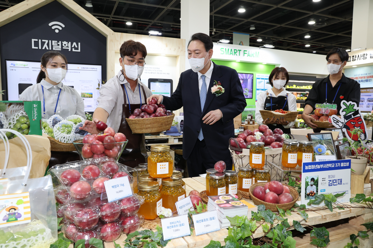 윤석열 대통령이 24일 오전 서울 서초구 aT센터에서 열린 2022 창농·귀농 고향사랑 박람회를 방문, 청년농부가 생산한 백향과를 살펴보고 있다. [연합]
