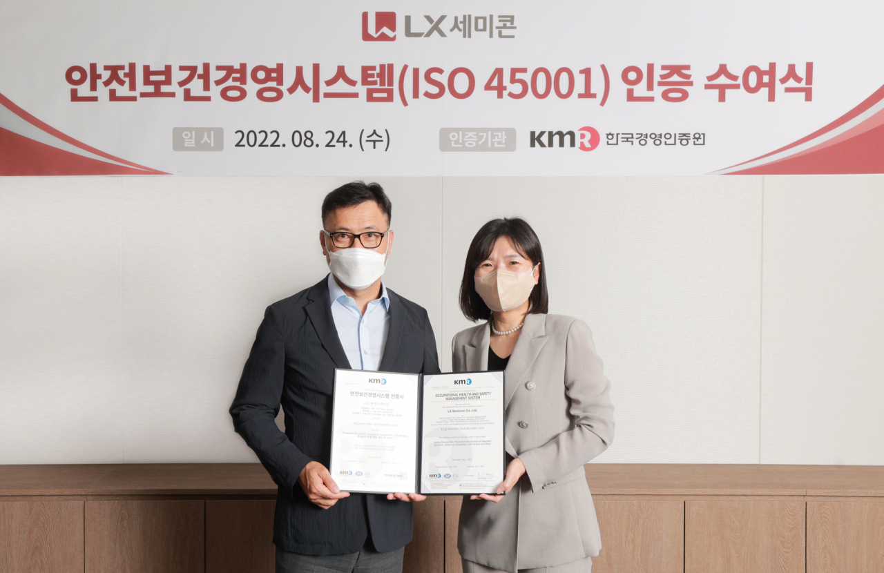 홍민석(왼쪽) LX세미콘 상무(CHO)와 황은주 한국경영인증원(KMR) 대표가 24일 LX세미콘 강남캠퍼스에서 열린 안전보건경영시스템(ISO 45001) 인증서 수여식에서 기념촬영을 하고있다. [LX세미콘 제공]