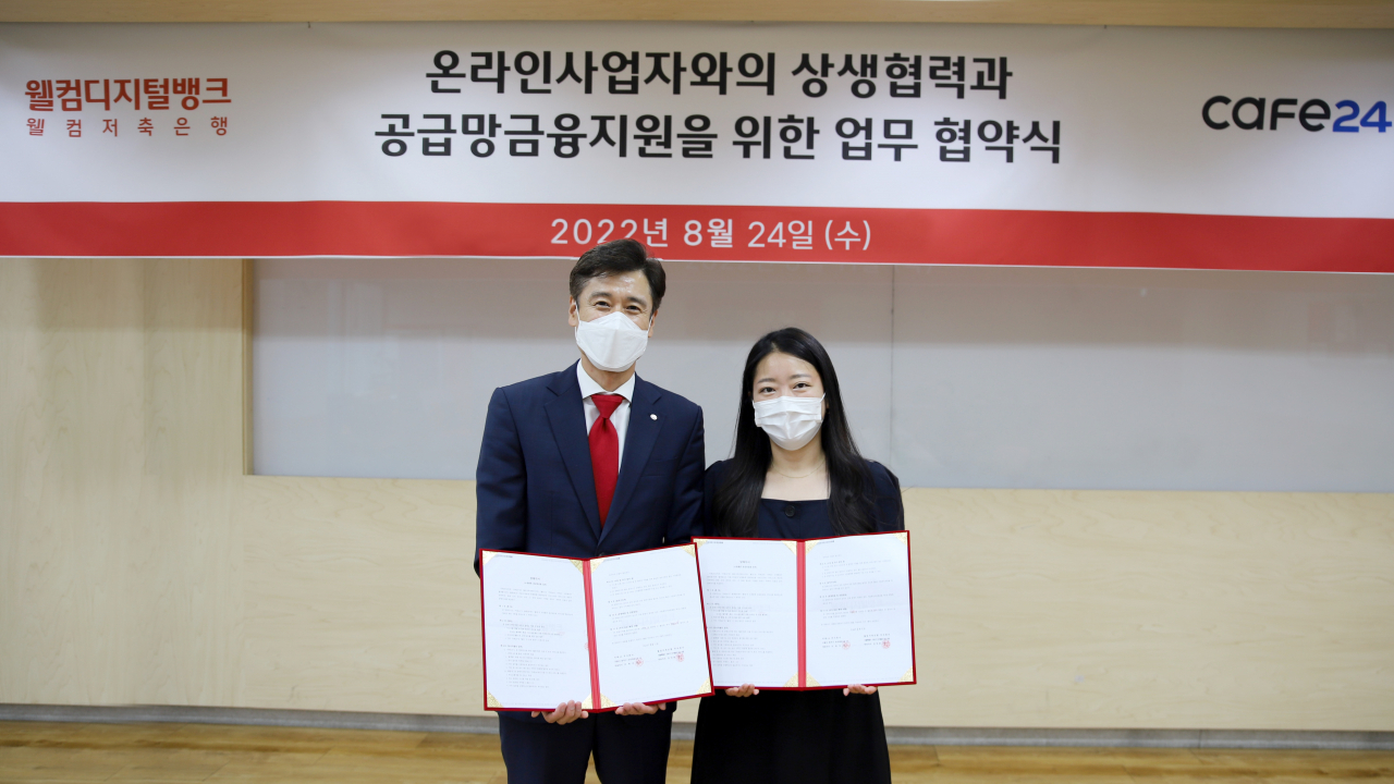 손창범(왼쪽) 웰컴저축은행 전무이사와 김하정 카페24 이사가 24일 구로구 웰컴저축은행 본사에서 온라인 사업자의 원활한 자금지원 및 성장을 돕기 위한 업무 협약을 체결하고 기념 촬영을 하고 있다.[웰컴저축은행 제공]