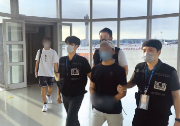 저금리 상환대출을 미끼로 120여 명의 피해자로부터 14억여 원을 가로챈 혐의를 받는 전화금융사기 조직 총책 A씨가 지난 24일 오후 인천국제공항을 통해 송환되고 있다. [경찰청 제공]