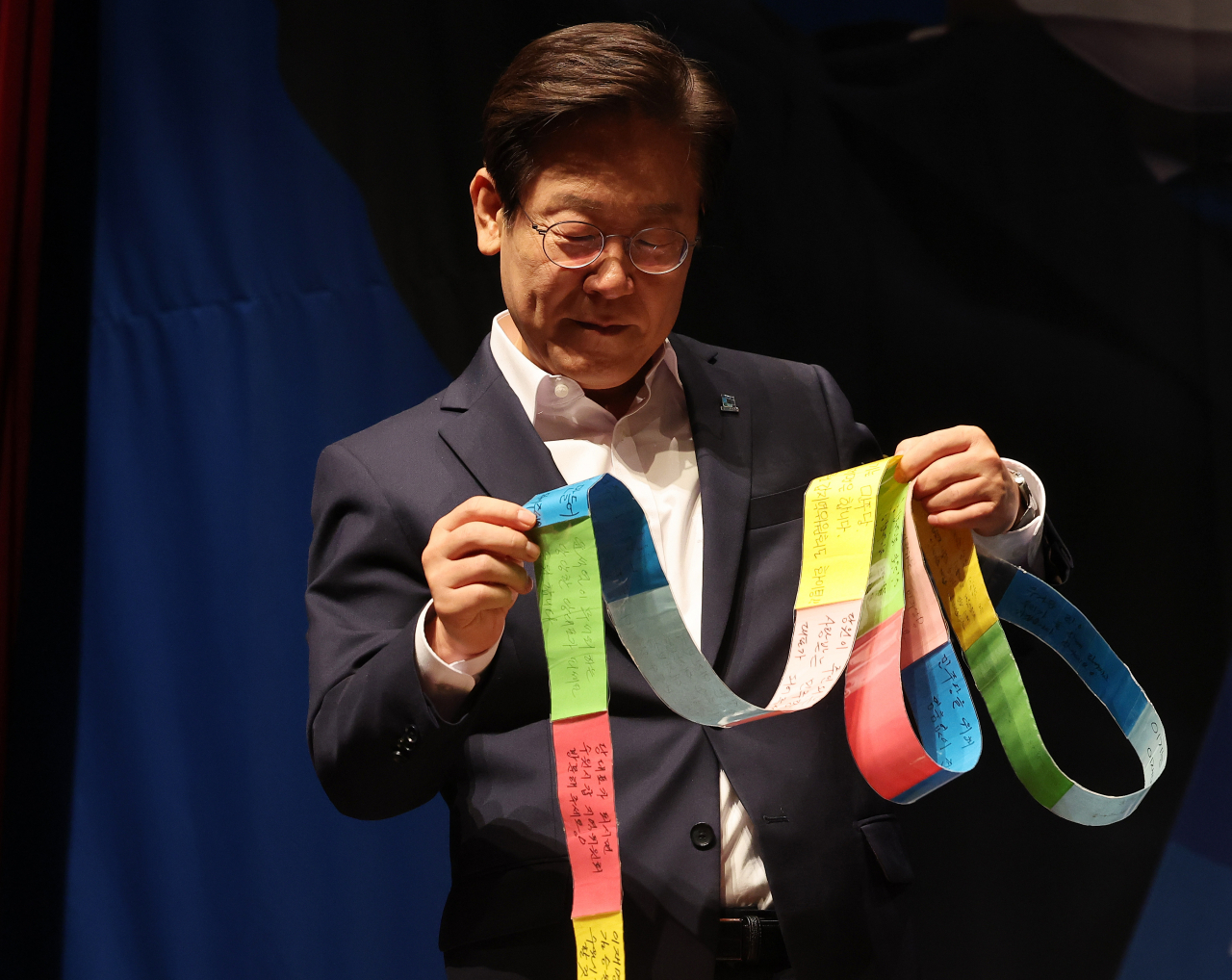 더불어민주당 이재명 당 대표 후보가 지난 24일 경기도 수원시 장안구민회관에서 열린 '경기도 당원 만남의 날'에서 지지자들이 남긴 메시지를 보고 있다. [연합]