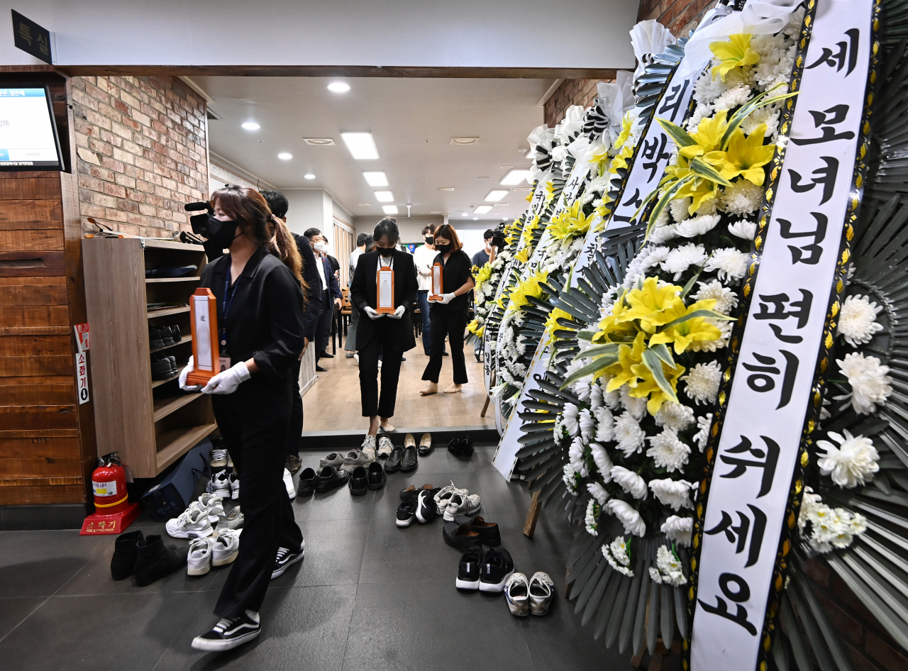 26일 오전 경기도 수원시 권선구 수원중앙병원 장례식장에서 열린 '수원 세모녀' 발인식에서 수원시 관계자들이 세 모녀의 위패를 옮기고 있다. [연합]