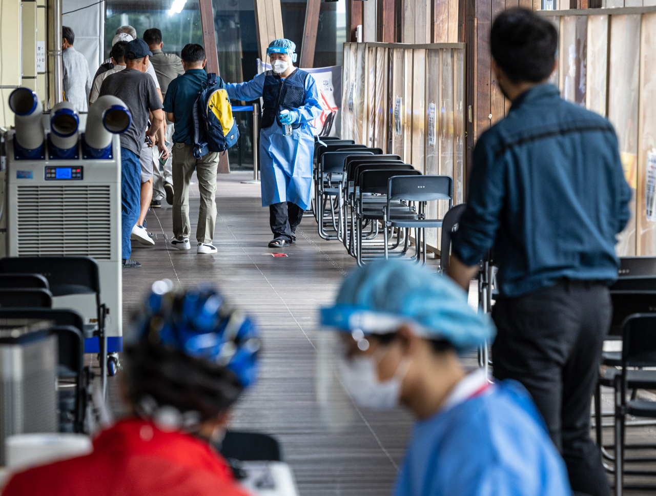 Citizens arrive at a COVID-19 testing station in Seoul on Wedneday. (Yonhap)