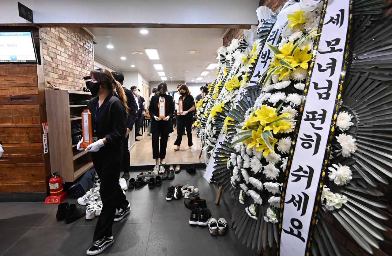 지난 26일 오전 경기 수원시 권선구 수원중앙병원 장례식장에서 열린 ‘수원 세모녀‘ 발인식에서 수원시 관계자들이 세 모녀의 위패를 옮기고 있다. [연합]