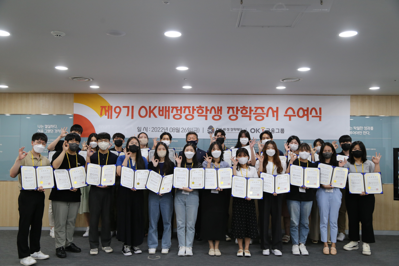 지난 26일 서울 남대문로에 위치한 OK금융그룹 본사 대회의실에서 진행된 제9기 ‘OK배정장학생’ 장학증서 수여식에서 최윤 OK금융그룹 회장(맨 뒷줄 가운데)을 비롯한 장학생들이 기념촬영을 하고 있다.[OK금융그룹 제공]