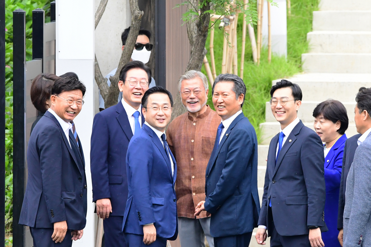 문재인 전 대통령이 29일 오후 경남 양산시 하북면 평산마을 사저를 찾은 이재명 더불어민주당 신임 대표 등 당 지도부들과 함께 지지자들을 향해 미소를 짓고 있다. [연합]