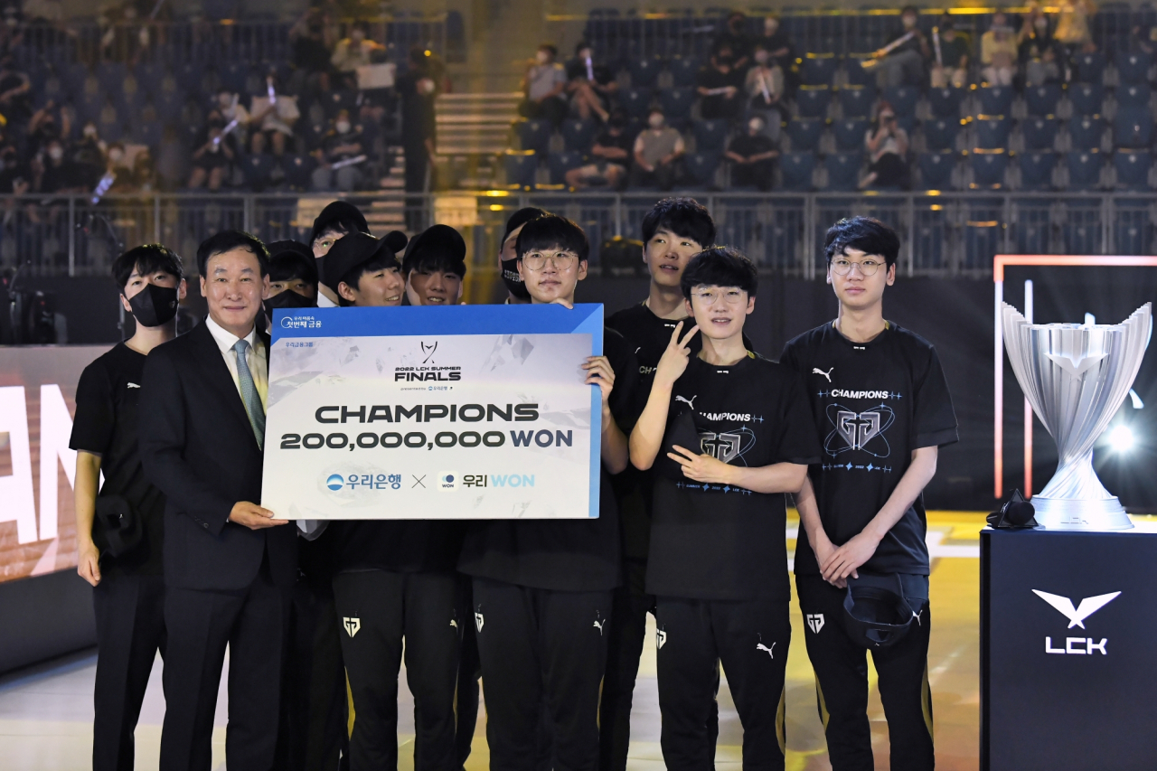 우리은행은 지난 28일 강릉 아레나에서 ‘우리은행과 함께하는 2022 LCK 서머 결승전’ 우승팀인 GEN.G에게 시상을 실시했다. 박완식 우리은행 개인/기관그룹 부행장(앞줄 왼쪽에서 첫번째)과 우승팀 GEN.G 선수단이 시상 후 기념촬영을 하고 있다.[우리은행 제공]