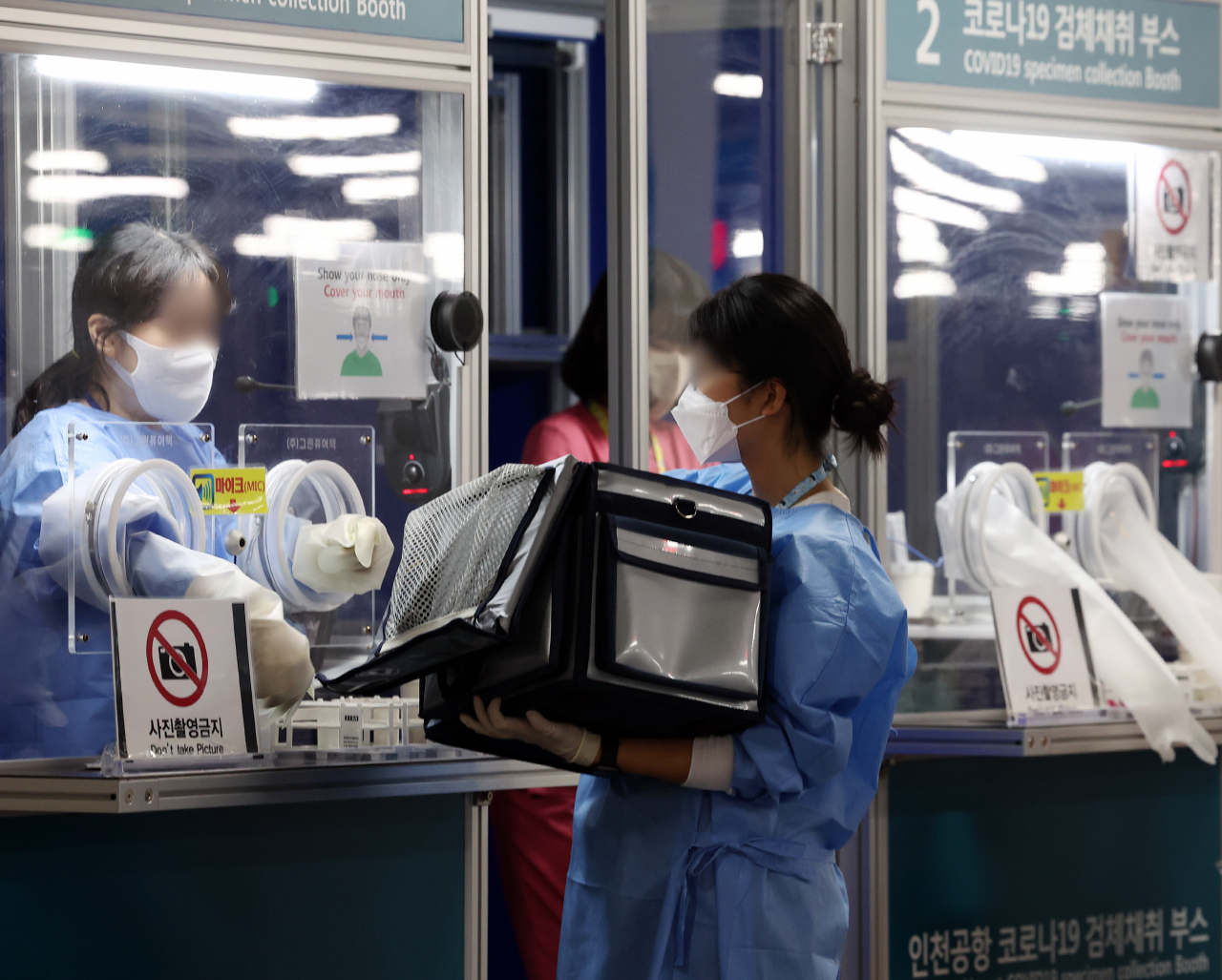 29일 오전 인천공항 제2터미널 코로나 검사센터에서 의료진이 검체를 옮기고 있다. [연합]