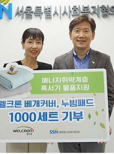 웰크론 신정재 사장(왼쪽)이 서울특별시사회복지협의회 김현훈 회장에게 침구세트를 전달하고 있다. [웰크론 제공]