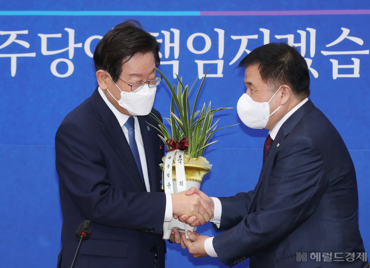 이재명 더불어민주당 대표가 30일 서울 여의도 국회에서 이진복 대통령실 정무수석으로부터 윤석열 대통령의 축하난을 전달받고 있다. 이상섭 기자