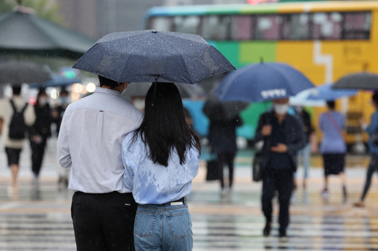 가을비가 내린 30일 서울 광화문사거리에서 긴팔옷을 입은 시민들이 우산을 쓴 채 이동하고 있다. [연합]