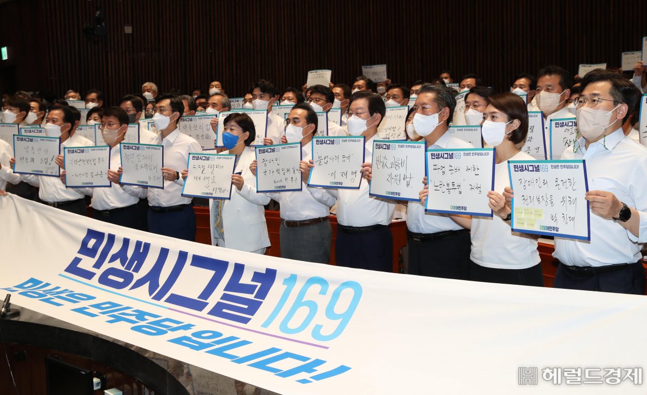 이재명 더불어민주당 대표와 박홍근 원내대표 등 의원들이 31일 오후 서울 여의도 국회에서 열린 ‘2022년 정기국회 대비 국회의원 워크숍’에서 1인 1민생입법 퍼포먼스를 하며 구호를 외치고 있다. 이상섭 기자