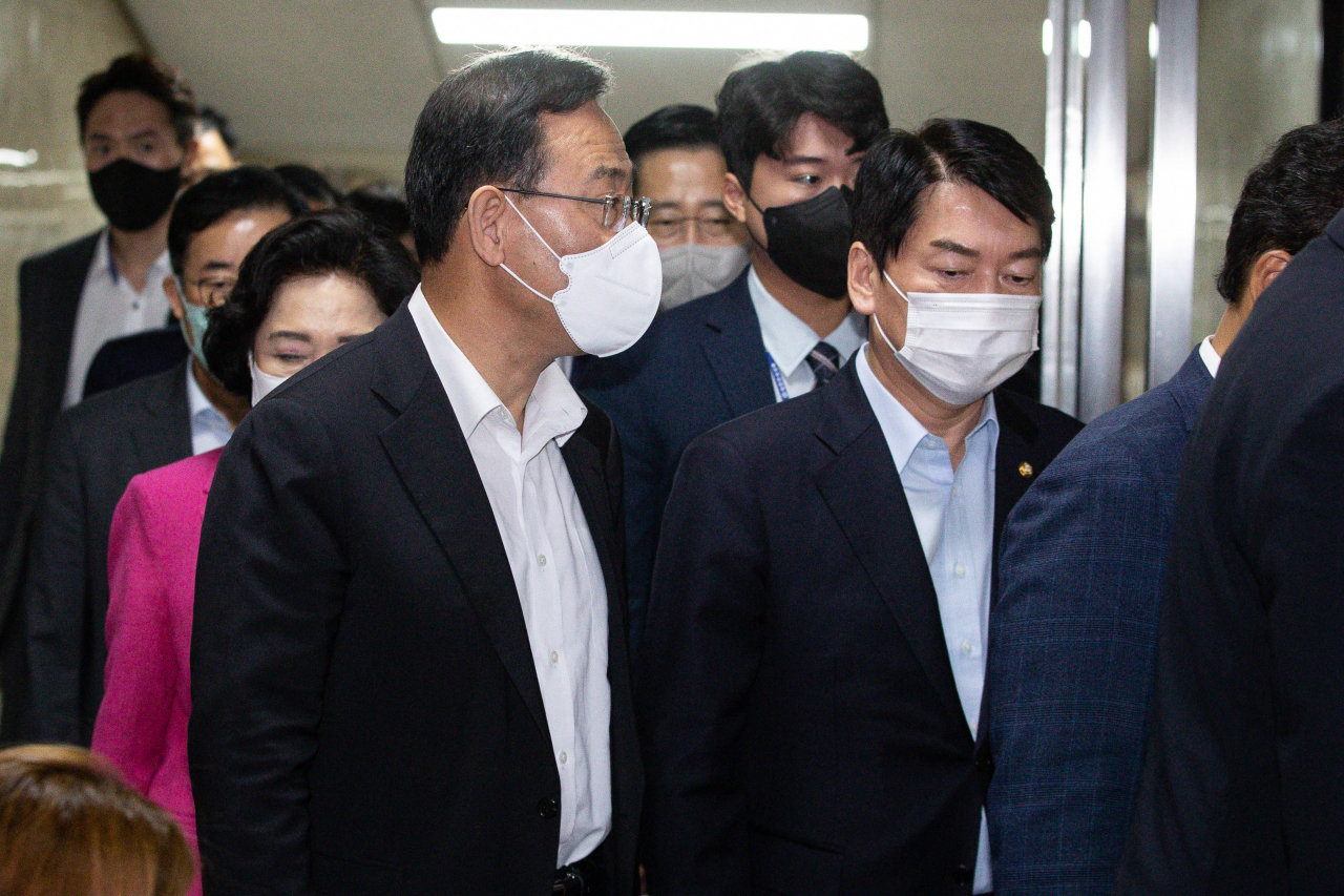 직무가 정지된 국민의힘 주호영(왼쪽) 비상대책위원장과 안철수(오른쪽) 의원이 30일 서울 여의도 국회에서 열린 의원총회가 정회되자 밖으로 나오고 있다. [연합]