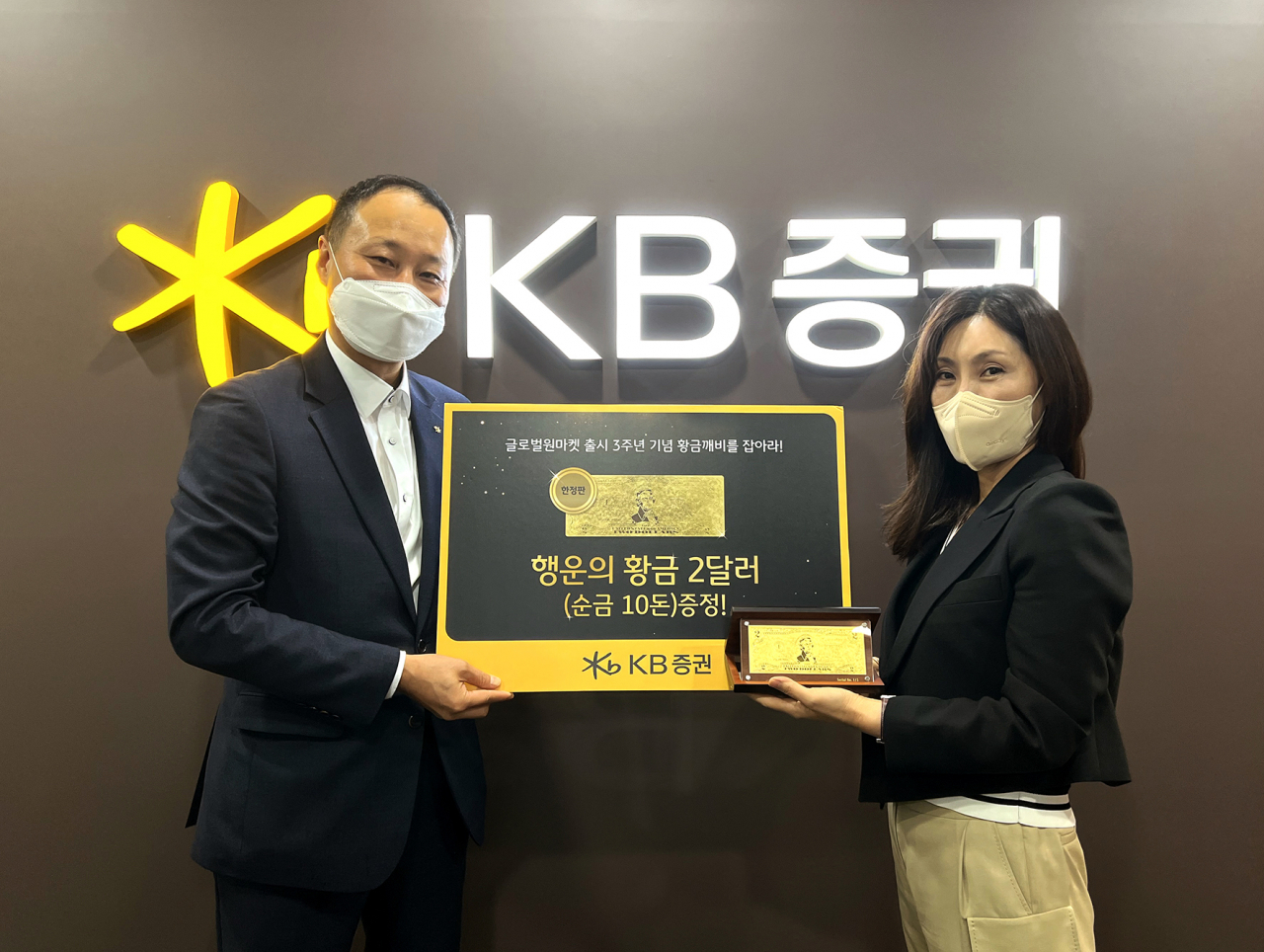 지난 30일 KB증권 창원지점에서 KB증권 WM영업본부장 윤만철 전무(사진 왼쪽)와 '황금깨비를 잡아라' 이벤트 행운의 황금 2달러 10돈 최초 당첨 고객이 경품증정 기념사진을 촬영하고 있다. [KB증권 제공]