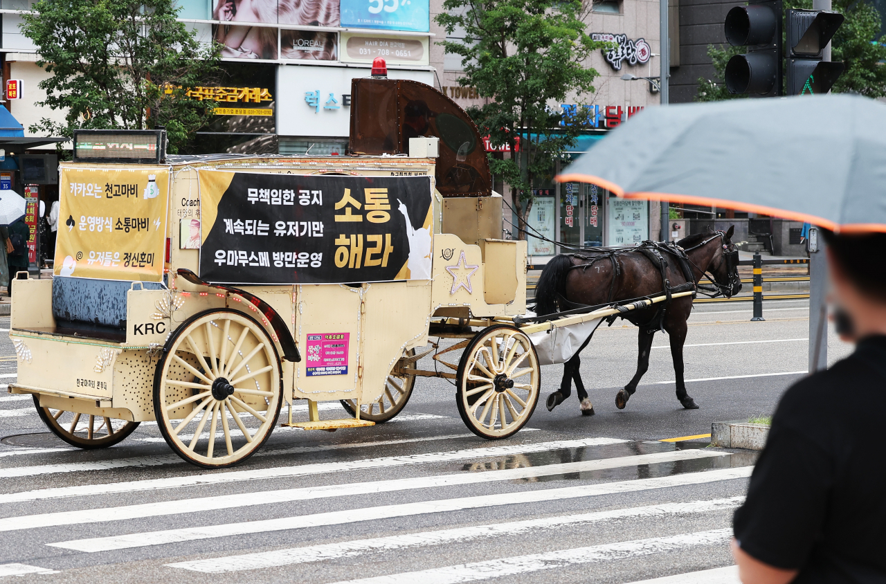 카카오게임즈의 '우마무스메:프리티 더비' 국내 이용자들이 게임사 측의 운영 방침에 반발하는 항의 문구 현수막을 붙인 마차가 지난 달 29일 오전 카카오게임즈 본사가 위치한 경기도 성남시 판교역 인근 도로를 달리고 있다. [연합]