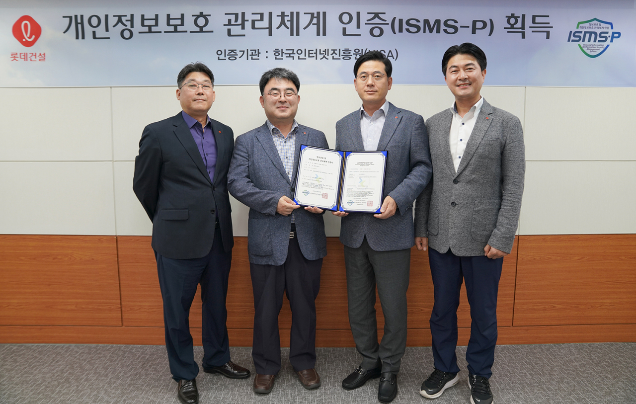 롯데건설 정보보호 관계자들이 ISMS-P 인증서를 들고 촬영하고 있다. (왼쪽부터 전략기획 부문 주영수 상무, 고객 개인정보보호 책임자 한정호 상무, 임직원 개인정보보호 책임자 고용주 상무, 정보보호 최고책임자 장흥순 부문장