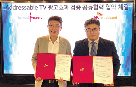 김경호 SK브로드밴드 방송광고담당(왼쪽)과 김기주 한국리서치 기획사업본부장이 SK브로드밴드 본사에서 진행된 어드레서블TV 광고효과 검증 공동협력 협약식에서 업무협약 후 기념사진을 찍고 있다. [SK브로드밴드 제공]