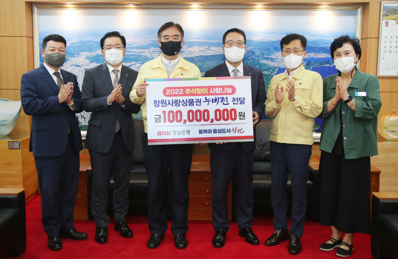 BNK경남은행 신태수 상무(사진 오른쪽 세번째)가 창원시 조명래 제2부시장에게 ‘창원사랑상품권 기탁 증서’를 전달하고 있다. [경남은행 제공]