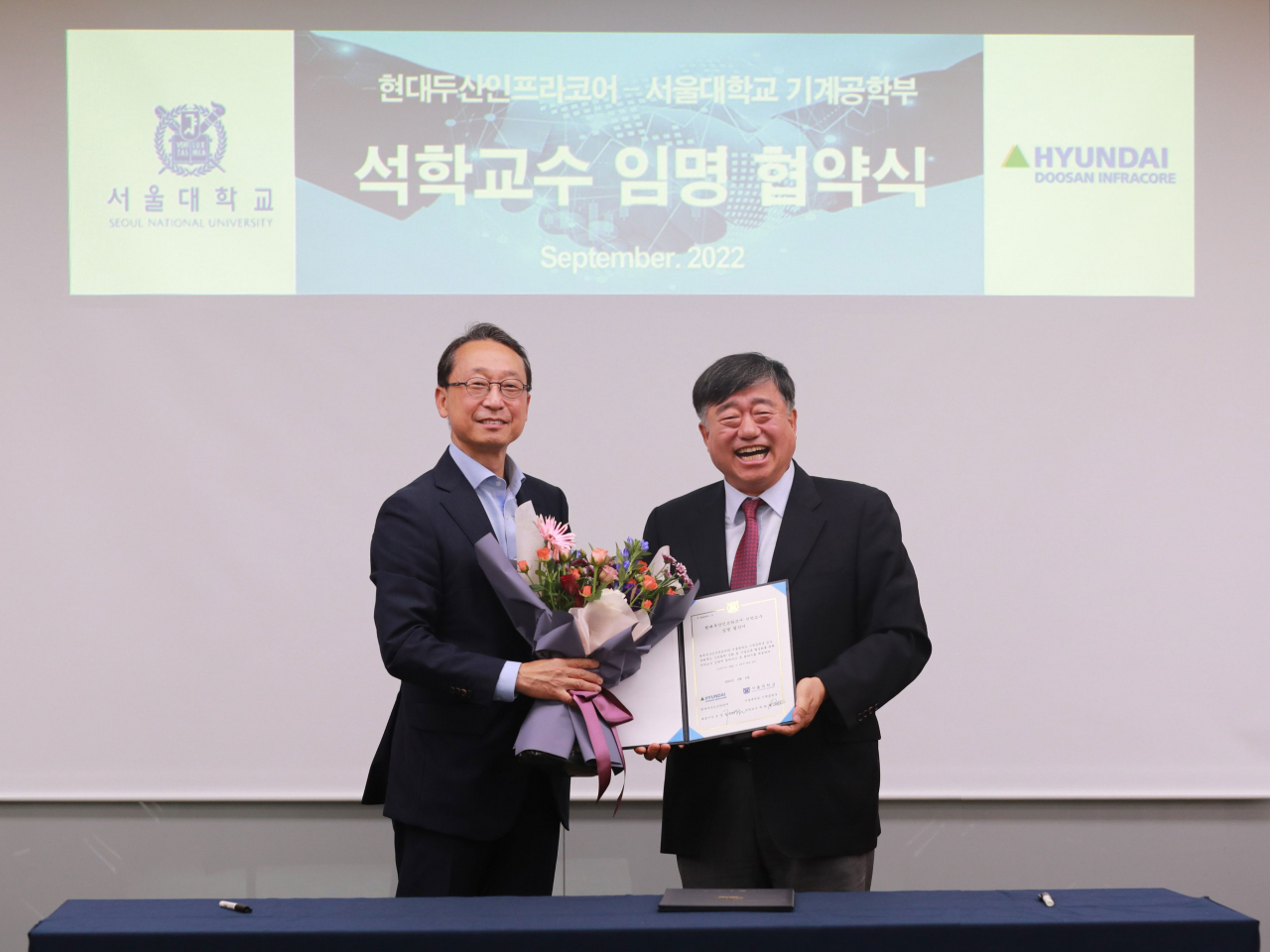 조영철(왼쪽) 현대두산인프라코어 사장과 박희재 서울대학교 기계공학부 석학교수가 지난 6일 서울대 공과대학에서 임명식을 진행 후 기념촬영을 하고 있다. [현대두산인프라코어 제공]