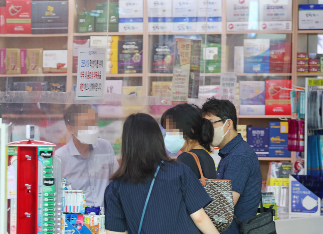 서울시는 추석 연휴인 9&sim;12일 ‘문 여는 병원과 약국’ 총 5228곳을 지정한 뒤 운영한다고 8일 밝혔다. 사진은 8월 15일 서울 시내의 한 약국 내부에서 시민이 약을 사고 있는 모습. [연합]