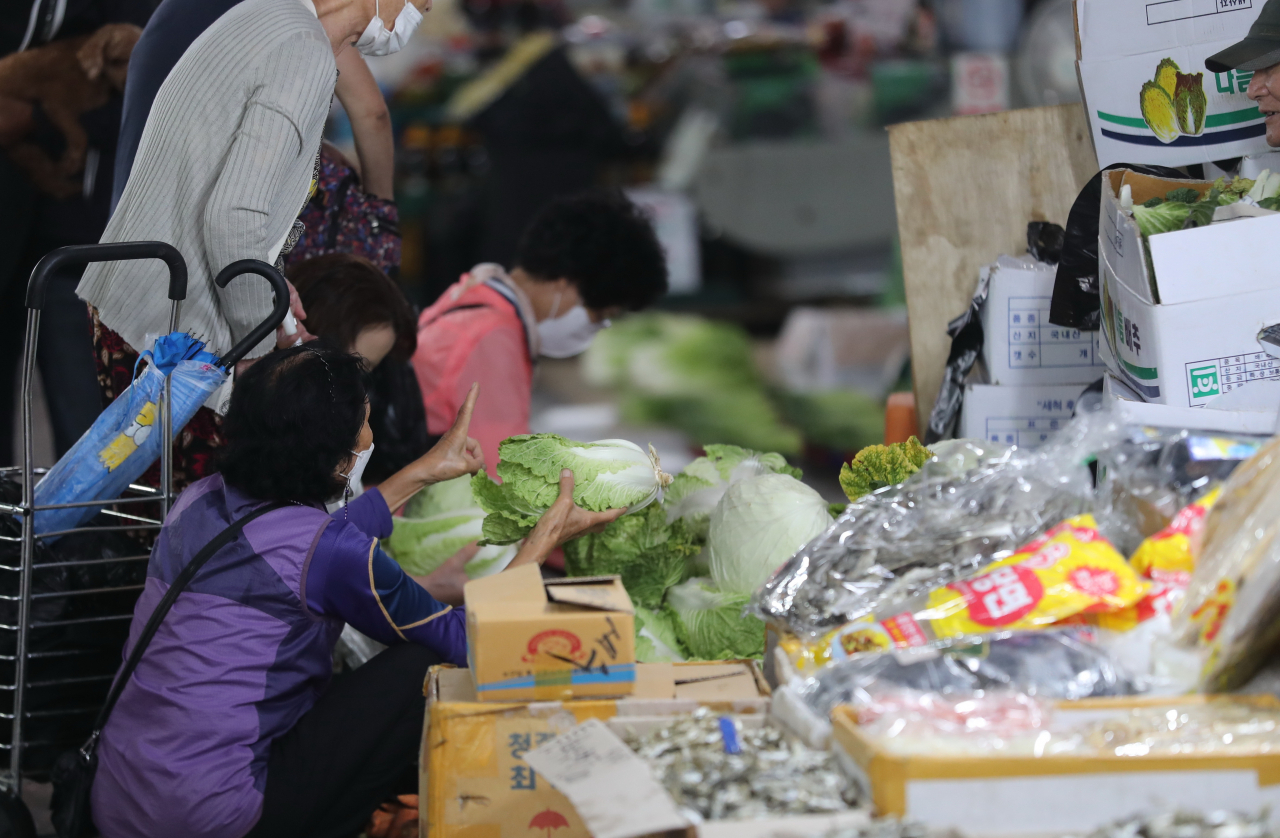 지난달 31일 오전 대전 중구 역전시장의 한 야채 가게에서 저렴한 배추를 사기 위해 손님들이 몰려있다. [연합]