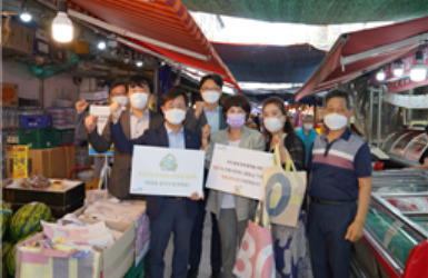 노사발전재단 정형우 사무총장(왼쪽)이 에코백 나눔 캠페인 후 마포공덕시장 상인회와 기념사진을 촬영하고 있다. [노사발전재단 제공]