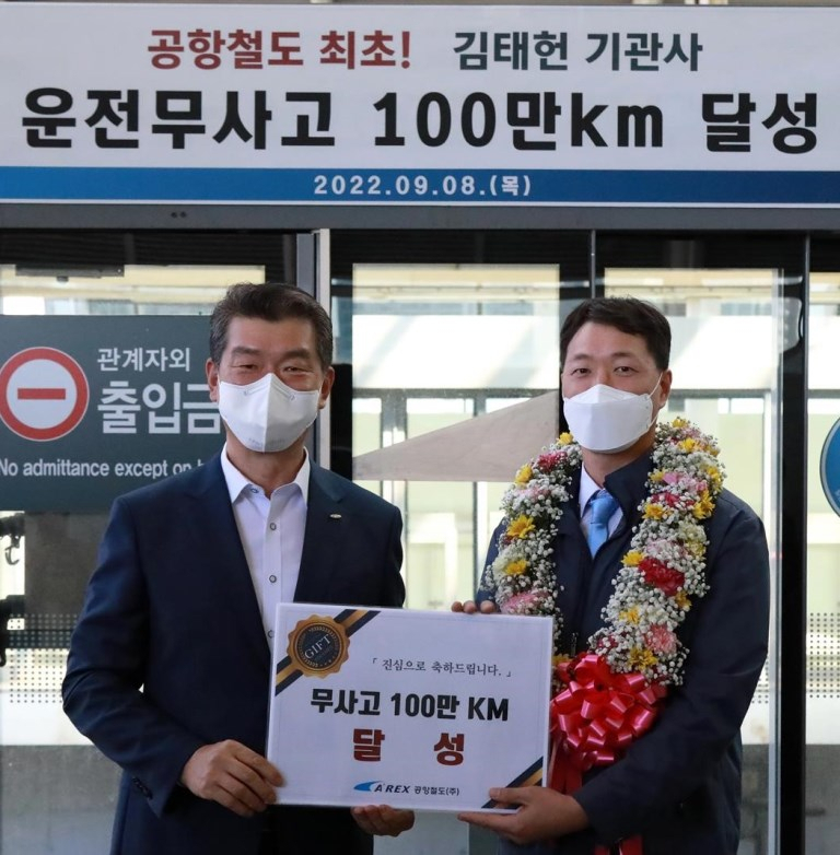 공항철도 김종대 부사장〈사진 왼쪽〉과 김태헌 기관사가 열차운전 무사고 100만km 달성 기념사진을 찍고 있다.