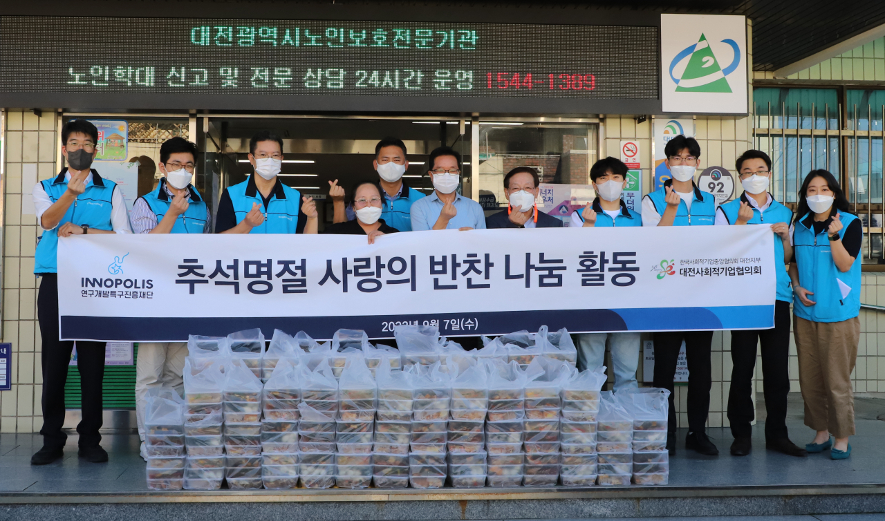 연구개발특구진흥재단 직원들이 대전사회적기업협의회와 함께 지역사회 소외계층을 위해 반찬을 포장해 오정동행정복지센터에 전달 후 기념사진을 찍고 있다.[특구진흥재단 제공]